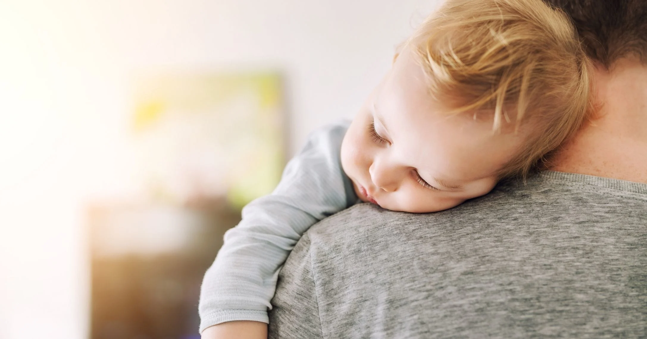 dad holding sleeping toddler