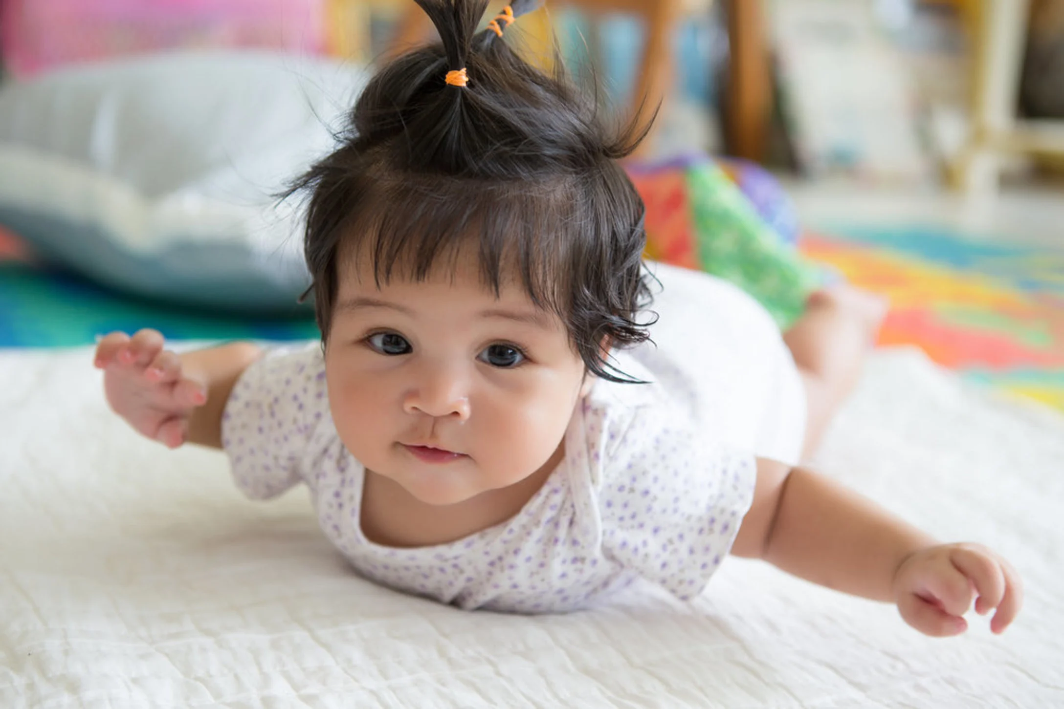 Asian baby girl lying on floor