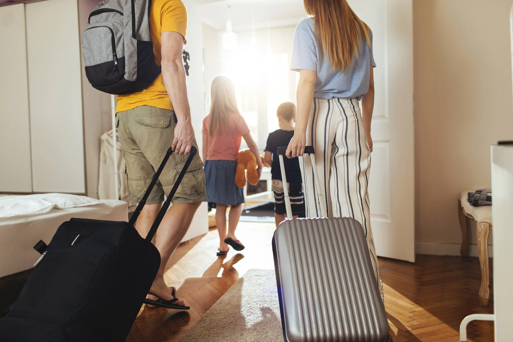 family pulling suitcases