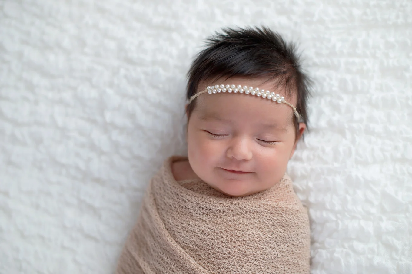 swaddled baby girl wearing headband